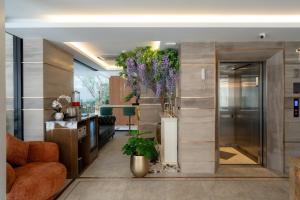 a living room with a large wall with purple flowers at Bestier Hotel Hatyai in Hat Yai +36 photos