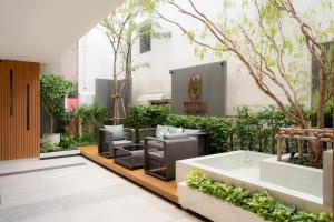 a courtyard with furniture and trees in a building at Bestier Hotel Hatyai in Hat Yai