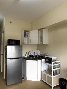 a small kitchen with a refrigerator and a sink at Atria Condo in Iloilo City