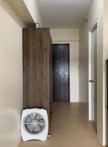 a fan sitting in a room with a door at Atria Condo in Iloilo City