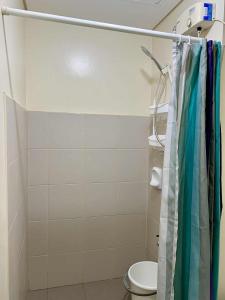 a bathroom with a shower curtain and a toilet at Atria Condo in Iloilo City +3 photos