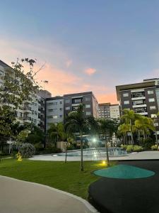 a park with palm trees in front of buildings at Atria Condo in Iloilo City