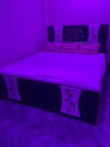 a purple bedroom with a bed with purple lights at Hotel Blue Mooon in Rājgīr