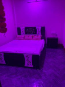 a purple bedroom with a bed with a purple light at Hotel Blue Mooon in Rājgīr