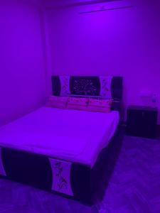a purple bedroom with a bed with purple lights at Hotel Blue Mooon in Rājgīr