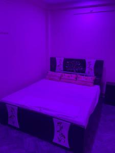 a purple bedroom with a bed with purple lighting at Hotel Blue Mooon in Rājgīr