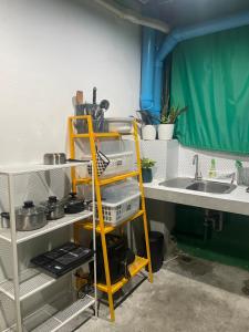 a kitchen with a yellow shelf next to a sink at MAXi MaMa Room in Bangkok +68 photos