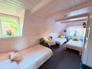 a bedroom with two beds and a table and a window at Wspaniały Zakątek in Sędziszowa