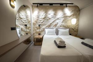 a bedroom with a bed and a stone wall at Euphoria Villa, 9 bdrs with private pools, beachfront in Kalogria +79 photos