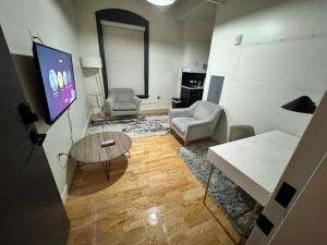 a living room with a tv and a table and chairs at Pratt St Brand New Studio Loft Elevator Building in Hartford +25 photos