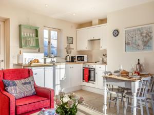 a kitchen with a red chair and a table at Fig Cottage - Ukc6129 in Eastdean +18 photos