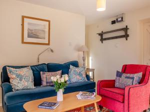 a living room with a blue couch and two red chairs at Fig Cottage - Ukc6129 in Eastdean