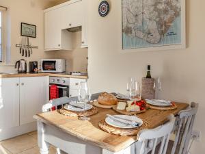 a kitchen with a table with food and wine glasses at Fig Cottage - Ukc6129 in Eastdean