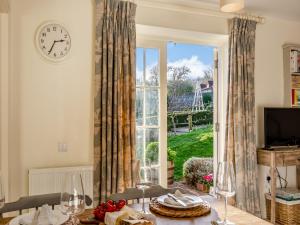 a living room with a clock and a large window at Fig Cottage - Ukc6129 in Eastdean