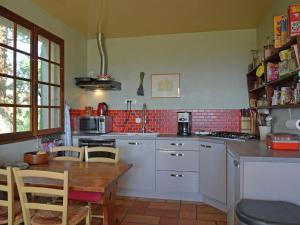 a kitchen with white cabinets and a table with chairs at Villa in Saint Privat de Champclos with pool in Barjac