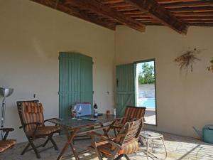 ein Esszimmer mit einem Tisch, Stühlen und einem Fenster in der Unterkunft Villa in Saint Privat de Champclos with pool in Barjac