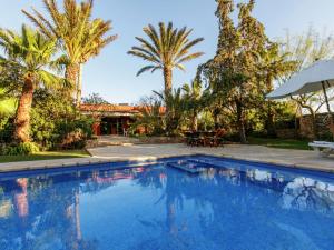 a swimming pool in a yard with palm trees at Holiday Home in St Josep de sa Talaia with Pool in Sant Josep de sa Talaia