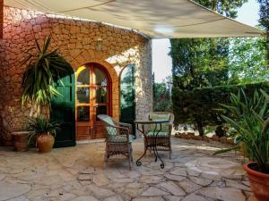 a patio with chairs and a table and an umbrella at Holiday Home in St Josep de sa Talaia with Pool in Sant Josep de sa Talaia