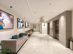a hallway with couches and paintings on the wall at Airotel in Pune