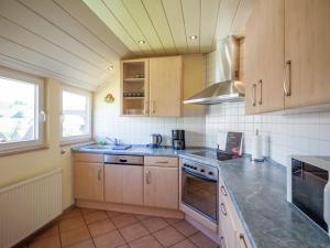 a kitchen with wooden cabinets and a counter top at Stunning Apartment in Bodefeld Germany near Ski Area in Schmallenberg