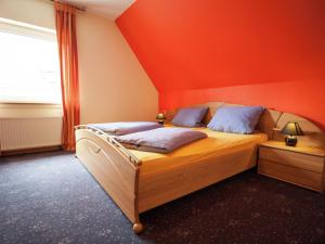 a bedroom with orange walls and a bed with blue pillows at Stunning Apartment in Bodefeld Germany near Ski Area in Schmallenberg