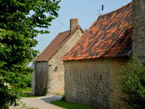 an old stone building with a red roof at Rural g te surrounded by fruit trees in Wierre-Effroy