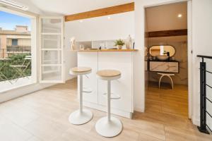 a kitchen with a bar and two stools at Saint Tropez High standing 3 in Saint-Tropez