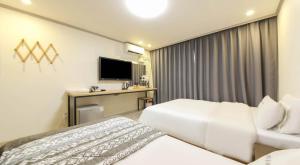 a hotel room with two beds and a television at 위드유 호텔 광주역 in Kwangju-yŏk +13 photos