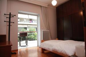a bedroom with a bed and a large window at Apartment Nikos in Thessaloniki