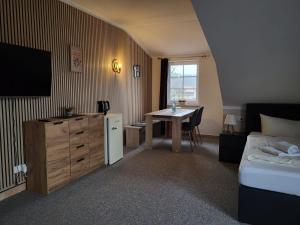 a bedroom with a bed and a table and a television at Holiday Park Auf dem Simpel in Soltau