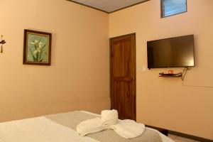 a room with a bed and a flat screen tv at La Estancia Ideal Apartamentos in Fortuna