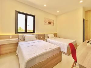 a bedroom with two beds and a window at Mui Da Hotel in Phan Thiet