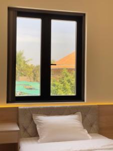 a bedroom with a window with a view of a bed at Mui Da Hotel in Phan Thiet