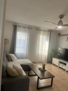 a living room with a couch and a coffee table at NEW Appart 2 chambres avec piscine proche aeroport in Les Abymes