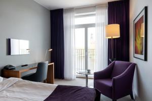 a hotel room with a bed and a desk and a chair at Elite Stadshotellet Eskilstuna, Hotel & Spa in Eskilstuna +66 photos