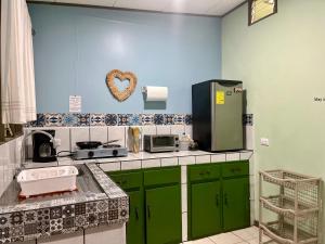 a kitchen with green cabinets and a heart on the wall at La Estancia Ideal Apartamentos in Fortuna