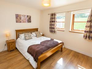 a bedroom with a bed and two windows at Laurel Cottage - Ukc6256 in Linlithgow