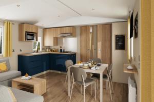 a kitchen and a living room with a table and chairs at Holiday Park Auf dem Simpel in Soltau