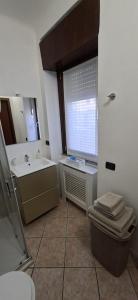 a bathroom with a toilet and a sink and a window at SISTERS GUEST HOUSE 2 in Somma Lombardo