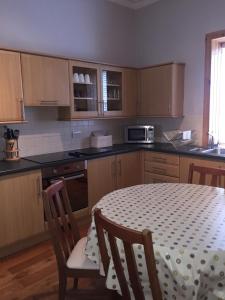 une cuisine avec une table et deux chaises et une table ainsi qu'une cuisine avec dans l'établissement Old Station House - Kilfillan Cottage, à Garlieston