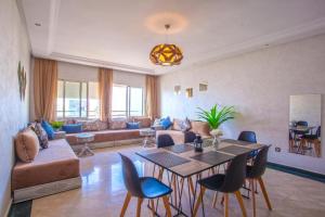 a living room with a couch and a table and chairs at riad dar bassou in Adrouine