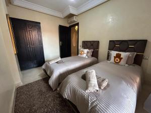 a bedroom with two beds with towels on them at riad dar bassou in Adrouine