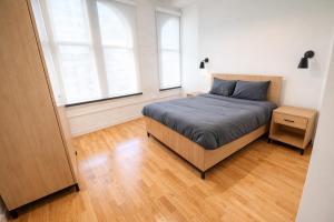 a bedroom with a bed and two windows at Pratt St Brand New Studio Loft Elevator Building in Hartford