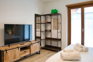 a living room with a flat screen tv on a entertainment center at NNHouse: large terrace and marvelous view in Cassina Valsassina