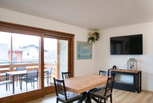 a dining room with a wooden table and chairs at NNHouse: large terrace and marvelous view in Cassina Valsassina