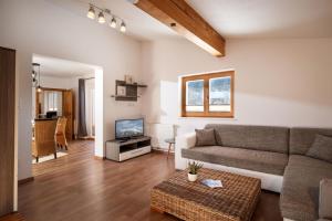 a living room with a couch and a tv at Harry's Hittn in Söll