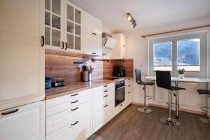 a kitchen with white cabinets and a table and chairs at Harry's Hittn in Söll
