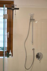 a shower with a shower head in a bathroom at NNHouse: large terrace and marvelous view in Cassina Valsassina +20 photos