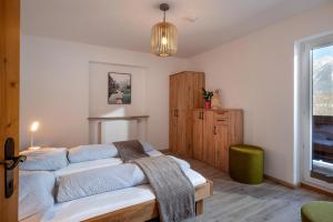 a bedroom with two beds and a large window at Harry's Hittn in Söll
