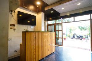 a restaurant with a wooden bar with a television on the wall at AARYA Corbett Resort & SPA - 8 minutes drive to Kosi River in Nainital